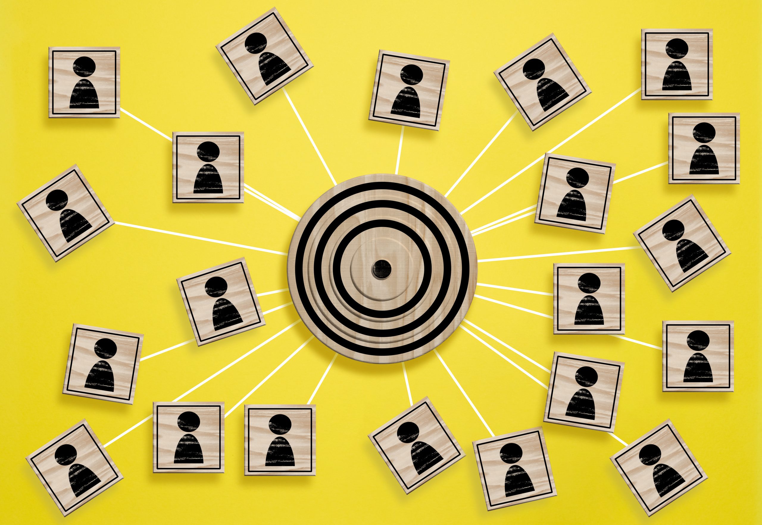 A wooden round target and wooden cubes with figure icon are connected, symbolizing the concept of target audience identification
