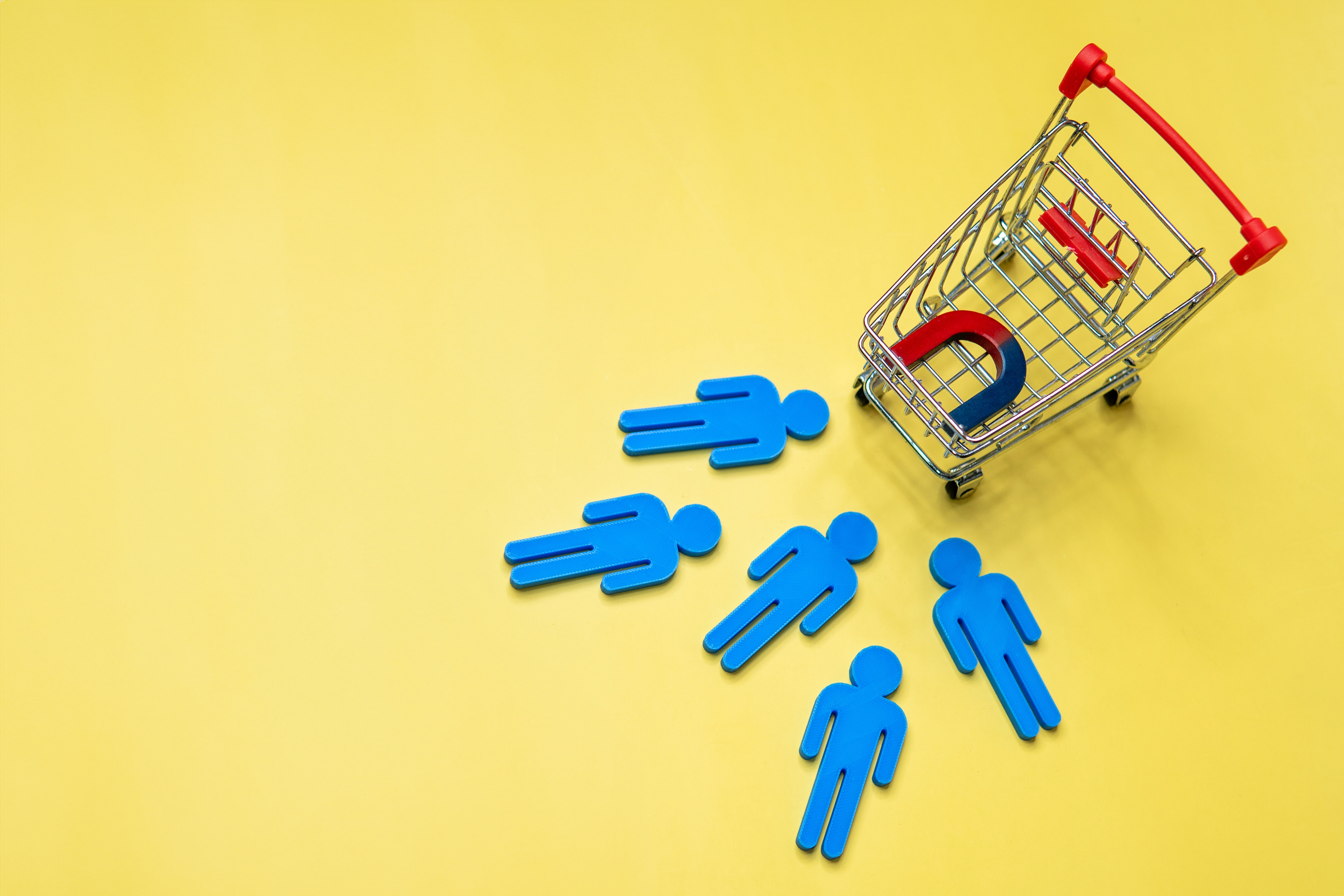 Magnet attract customers towards the shopping cart. Copy space for text. Attract customers and customer acquisition concept.